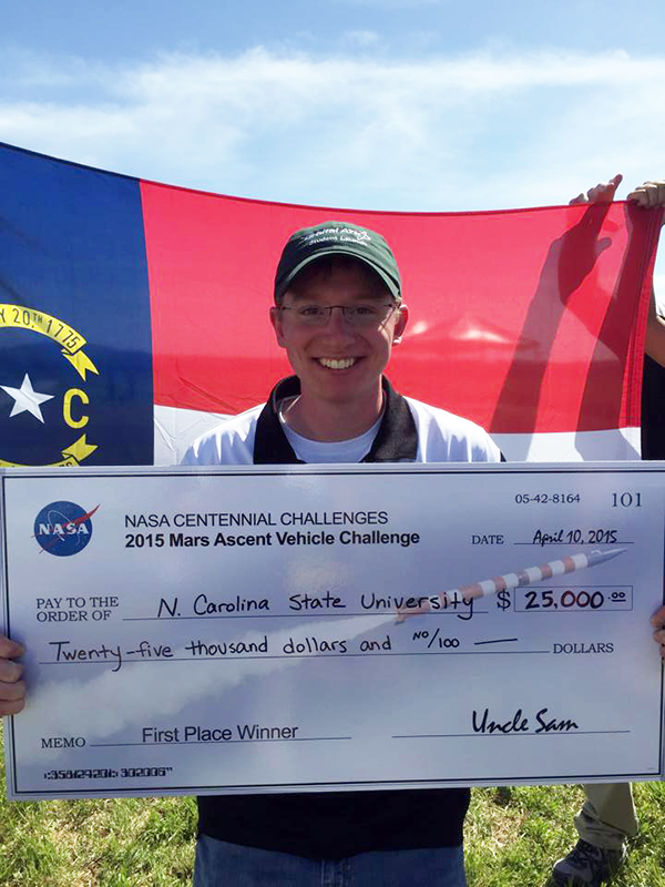 Lauer holds up the check from the high-powered rocketry team's big win at the 2015 NASA Centennial Challenge competition. 