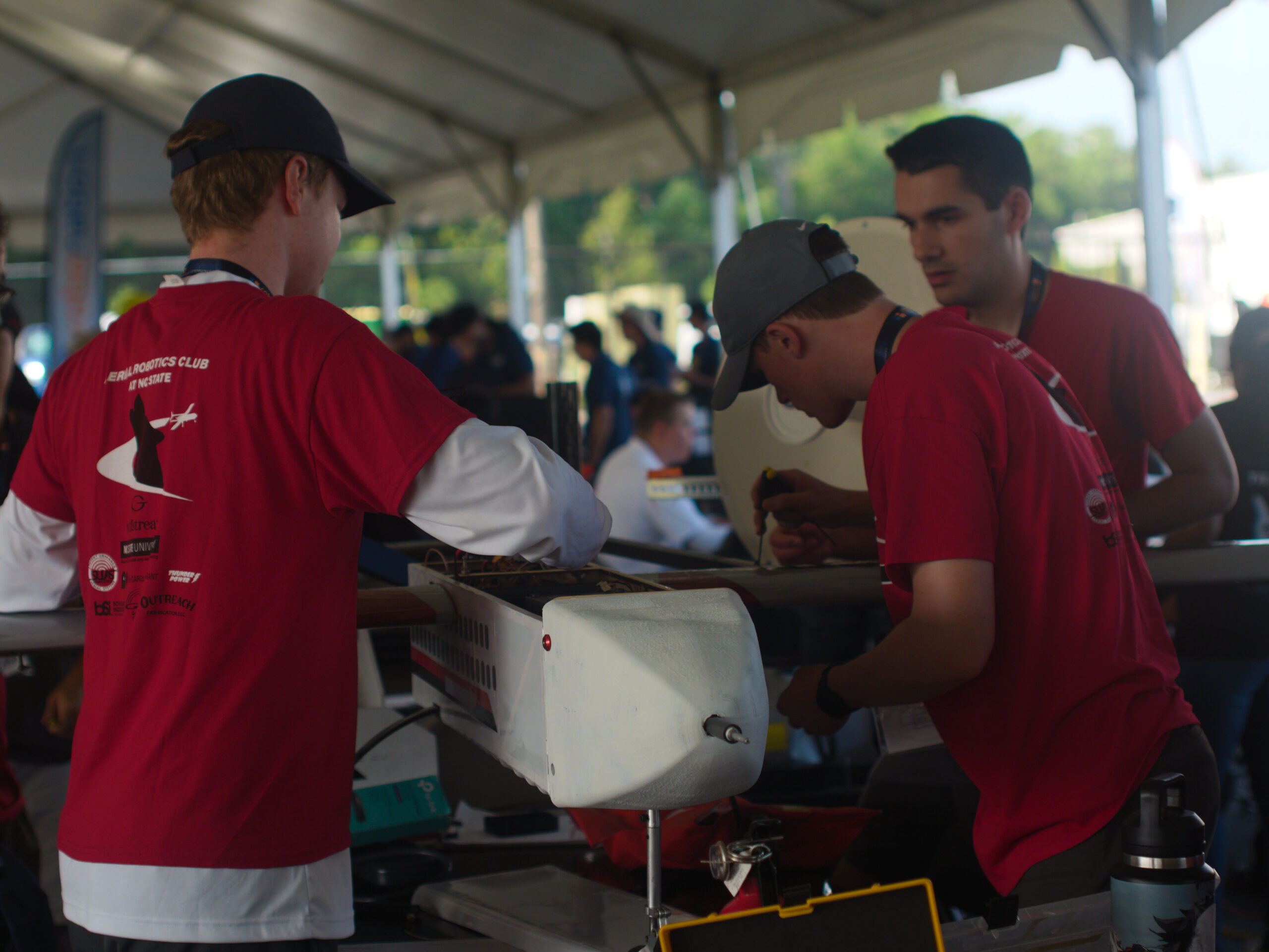 Three students working on a small airplane