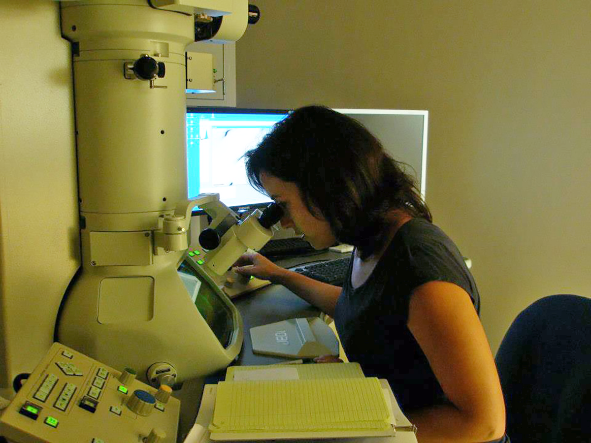 Ashley Roberts peers into a microscope while working in a microscopy lab in 2010.