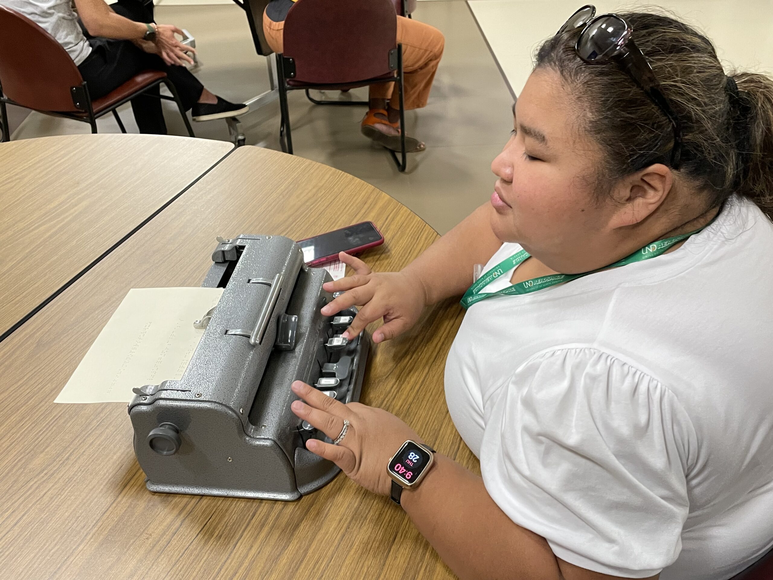Woman closes her eyes to type on a braille keyboard